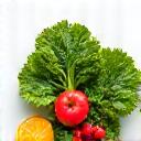Green vegetables and fruits arranged aesthetically, representing nutrition.